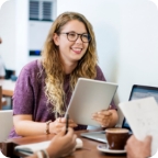 Businessperson smiles and holds a notebook.